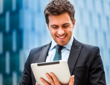 businessman looking at tablet smiling