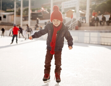 little kid skating on outside ice rink